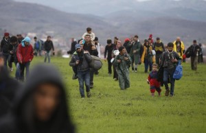 Migrants walk through a field looking for a way to cross the Greek-Macedonian border, near the village of Idomeni March 14, 2016. REUTERS/Stoyan Nenov