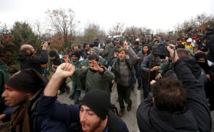 Migrants run from Greek riot police as they look for a way to cross the Greek-Macedonian border, near the village of Idomeni, Greece, March 14, 2016. REUTERS/Stoyan Nenov